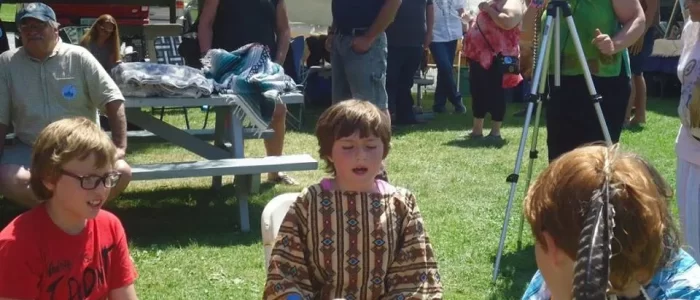 Children sitting around a large drum